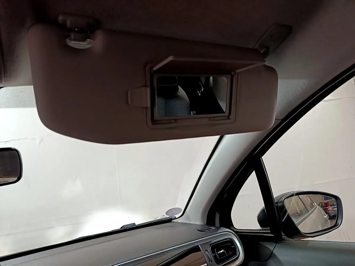 Miroir de courtoisie ouvert sur pare-soleil côté conducteur dans l'habitacle beige d'une Citroën C3 2022.