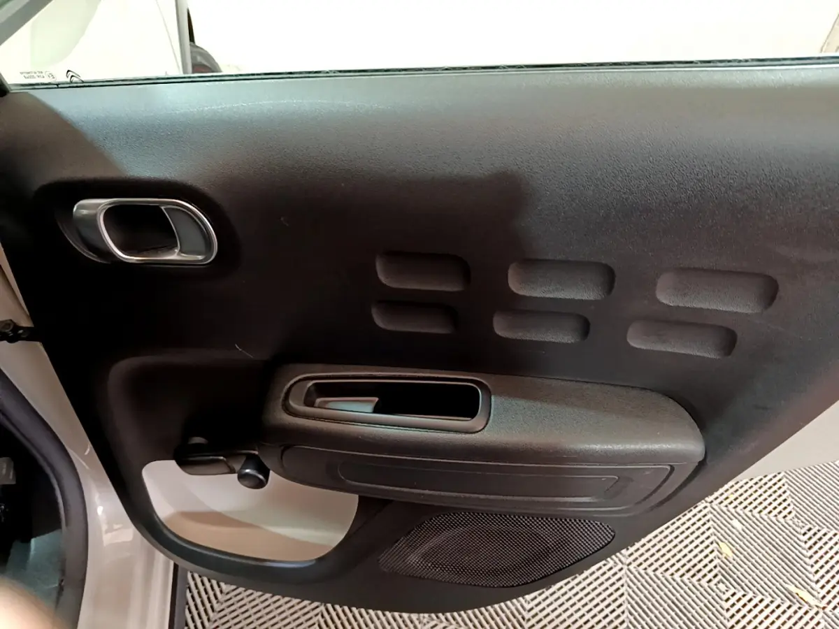 Vue rapprochée de la porte avant gauche beige de la Citroën C3 2022 avec poignée et panneau noir texturé.