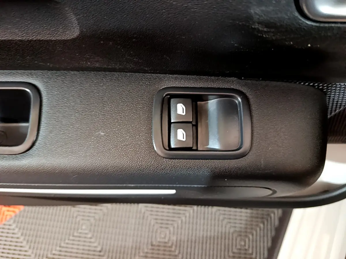 Gros plan sur les commandes de lève-vitres côté conducteur de la Citroën C3 beige 2022.