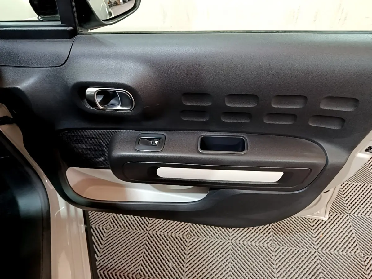 Vue rapprochée de la porte avant gauche beige de la Citroën C3 2022 avec poignée chromée et commandes électriques.