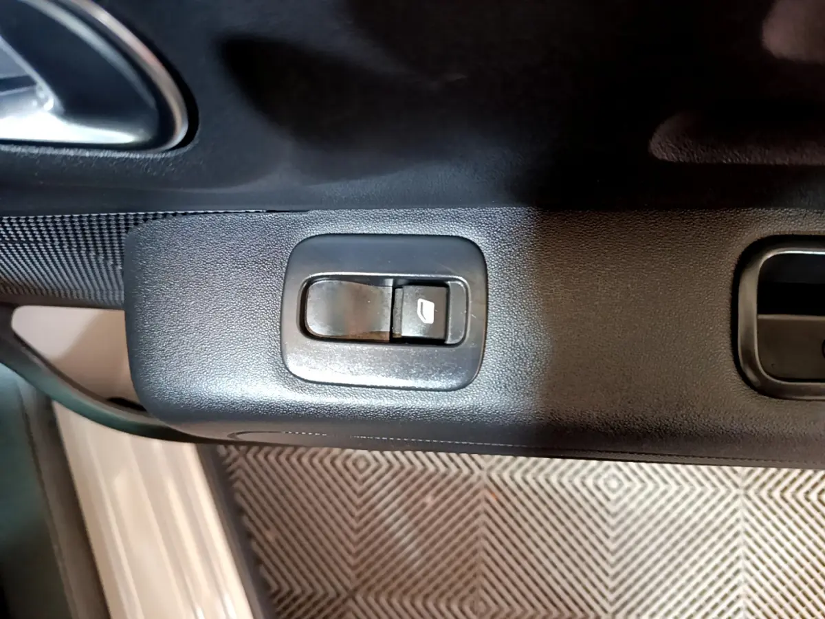 Bouton de commande de lève-vitre sur la portière côté conducteur d'une Citroën C3 beige 2022.