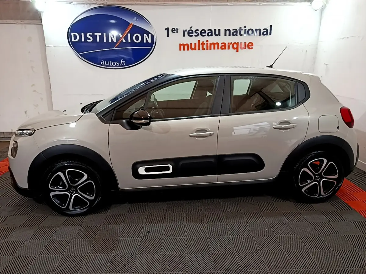 Profil côté gauche d'une Citroën C3 beige 2022 avec protections noires et jantes alliage distinctives.