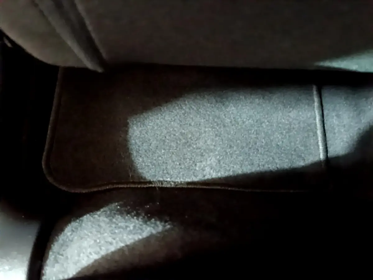 Tapis de sol noir sous le siège avant dans l'habitacle d'une Citroën C3 beige 2022 PureTech Feel Pack