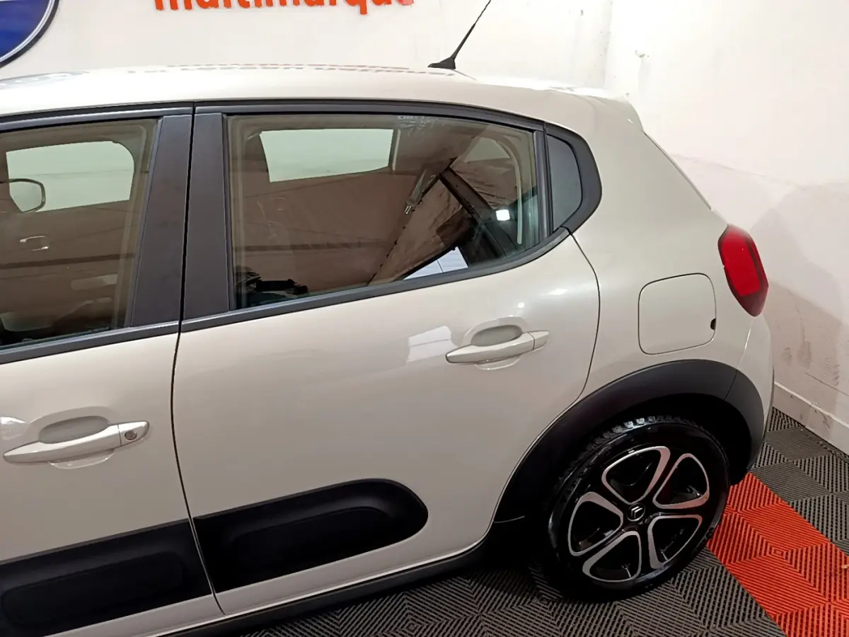 Vue latérale côté droit d'une Citroën C3 beige 2022 avec protections noires et jantes alliage distinctives.