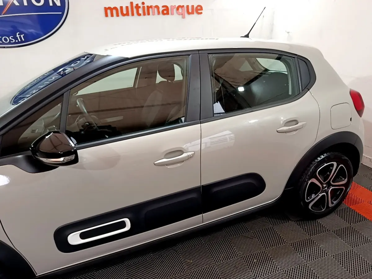 Vue latérale droite d'une Citroën C3 beige 2022 avec protections noires et jantes alliage distinctives.
