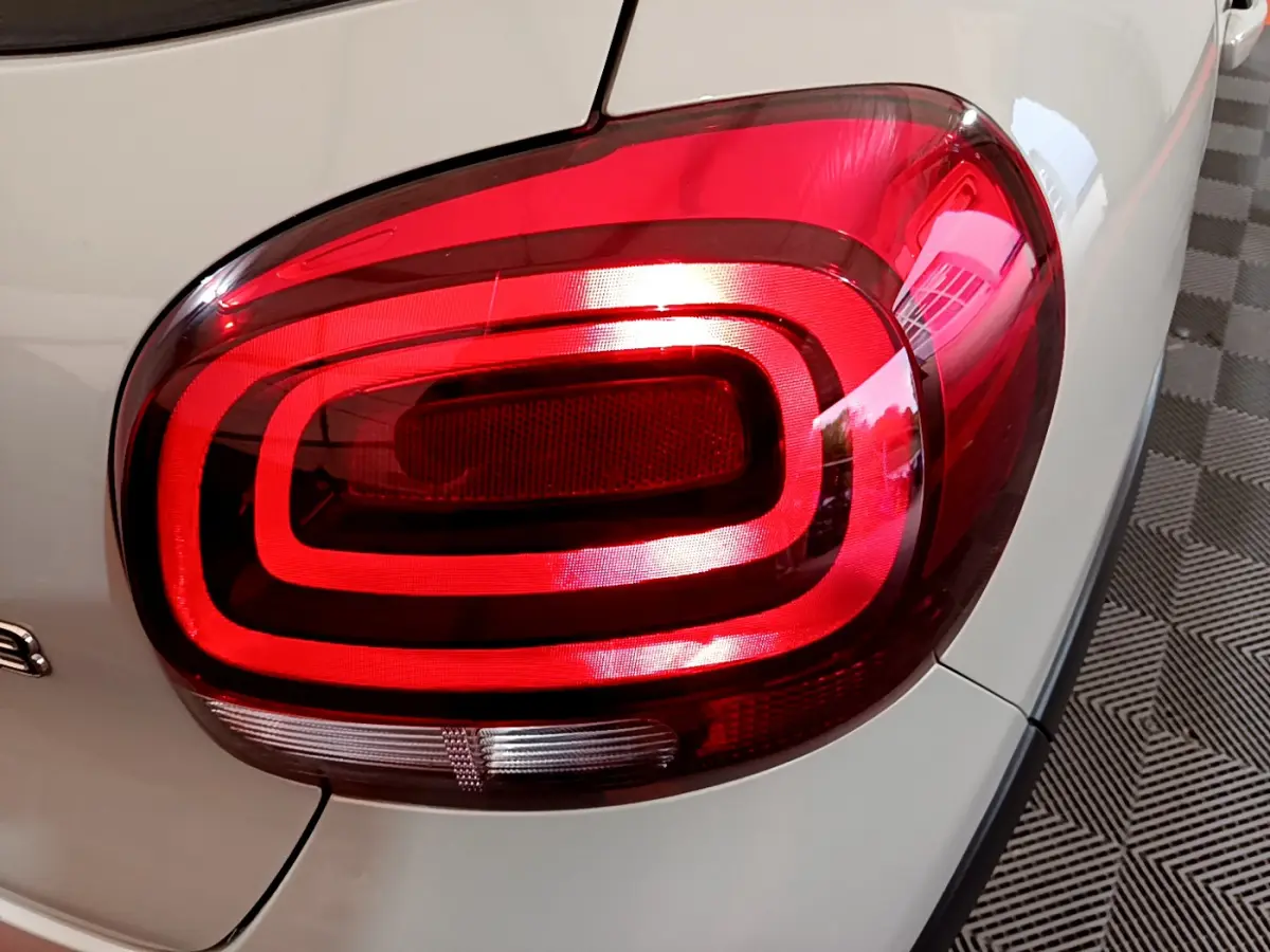 Gros plan sur le feu arrière droit rouge d'une Citroën C3 beige 2022, mettant en valeur son design lumineux distinctif.