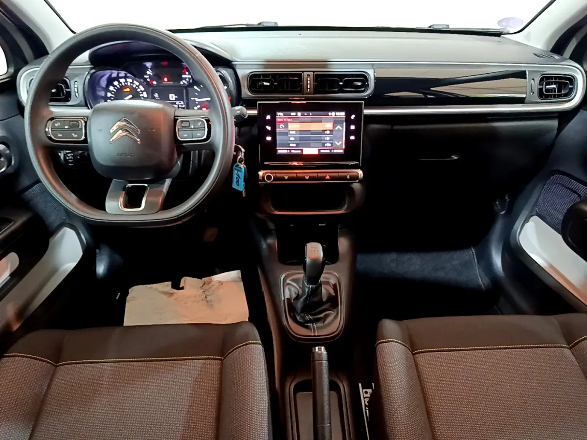 Vue intérieure avant de la Citroën C3 beige 2022, tableau de bord avec écran tactile et volant multifonctions.