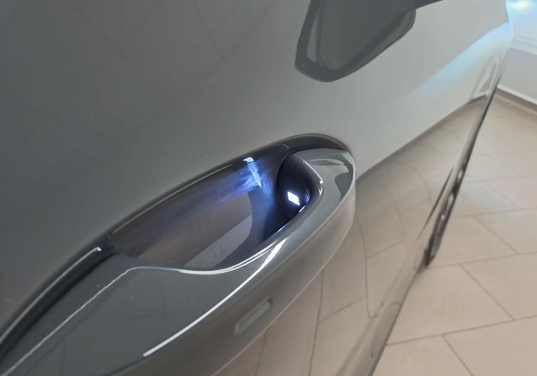 Poignée de porte avant droite éclairée sur Volkswagen Tiguan 2024 Gris Urano, vue rapprochée côté droit.