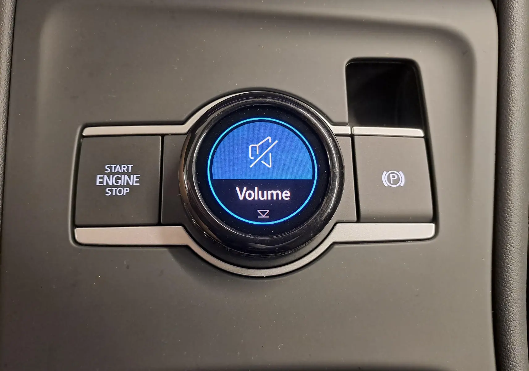 Gros plan sur la molette de volume et les boutons Start/Stop et frein à main électrique du Volkswagen Tiguan 2024.