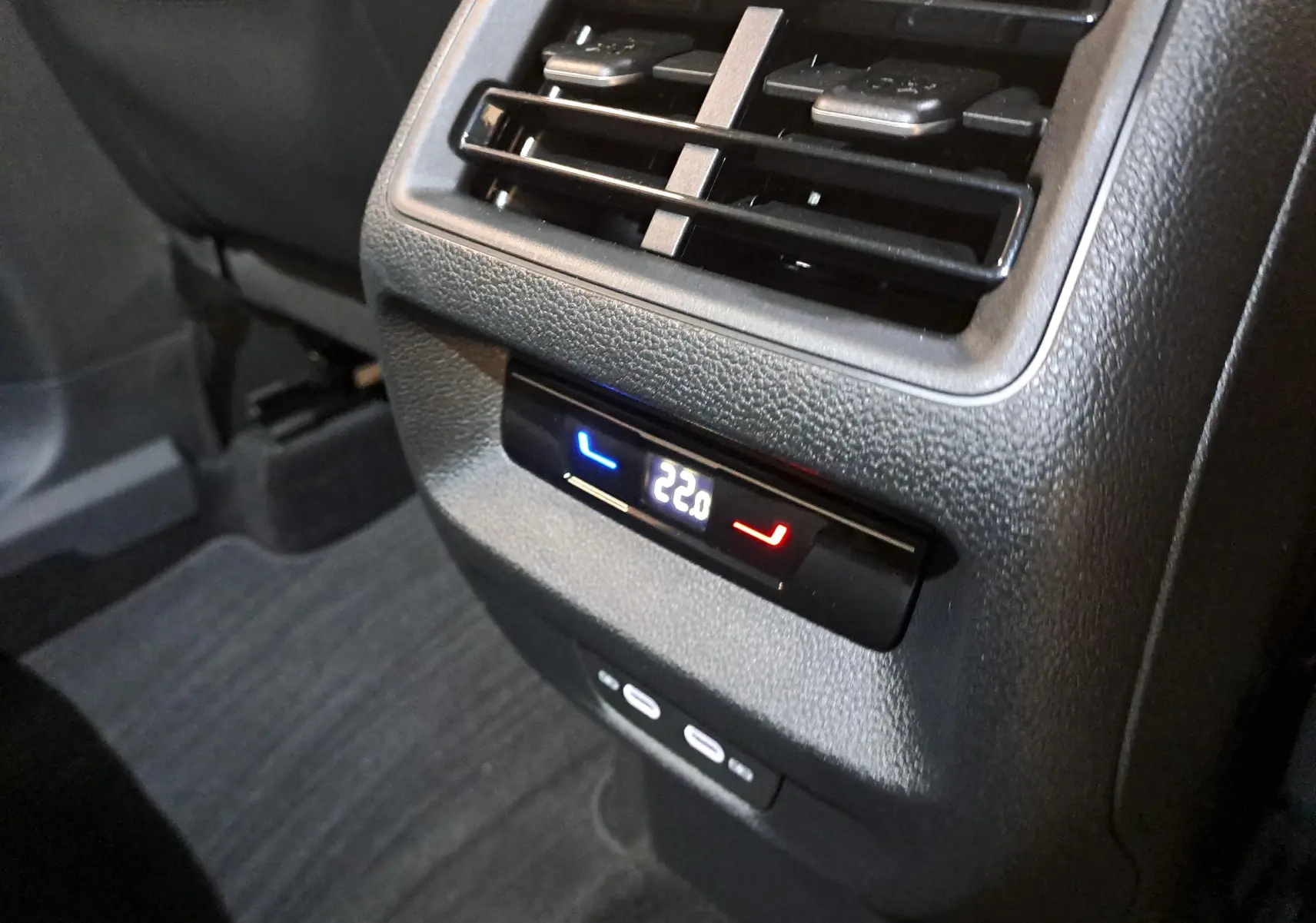 Détail de la console arrière du Volkswagen Tiguan 2024 gris Urano, montrant la ventilation et le réglage de température à 22°C.