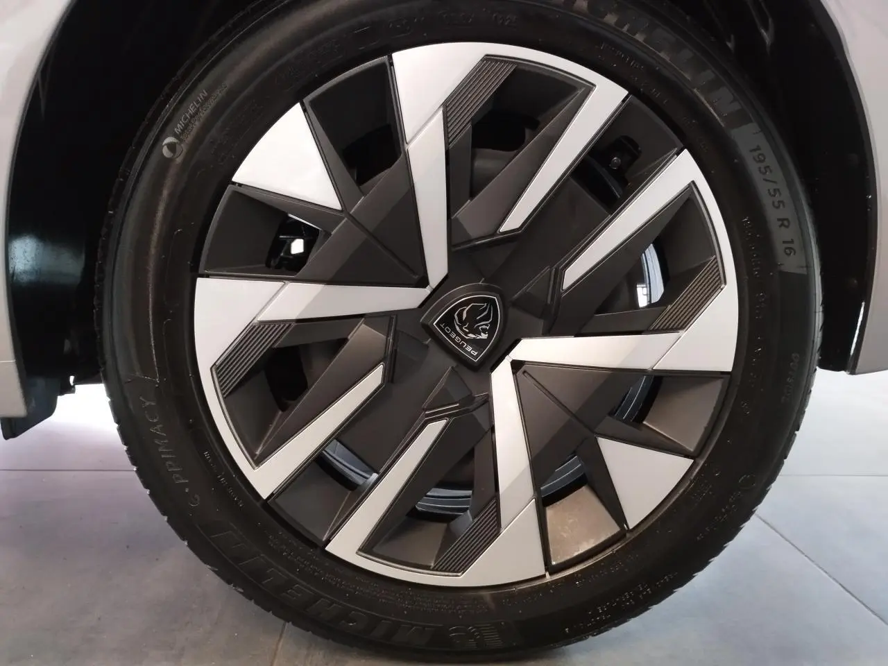 Gros plan sur la jante 16 pouces bicolore noire et argentée de la Peugeot 208 gris clair 2025.