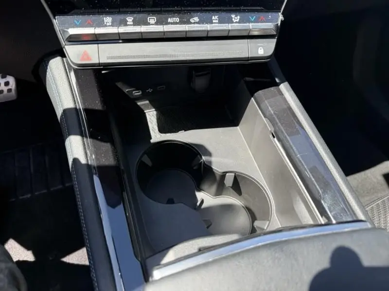 Vue rapprochée de la console centrale du Renault Austral 2023, avec porte-gobelets et commandes de climatisation visibles.