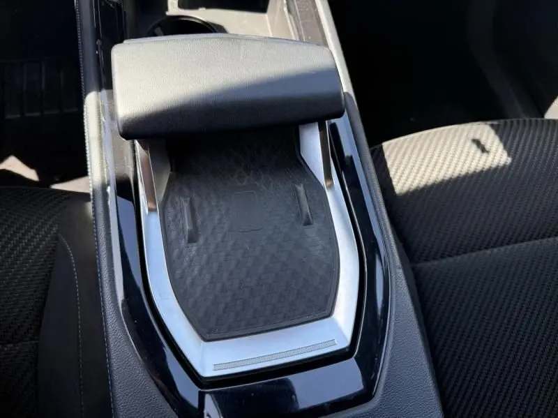 Gros plan sur la console centrale noire du Renault Austral 2023, avec accoudoir et surface texturée au centre.