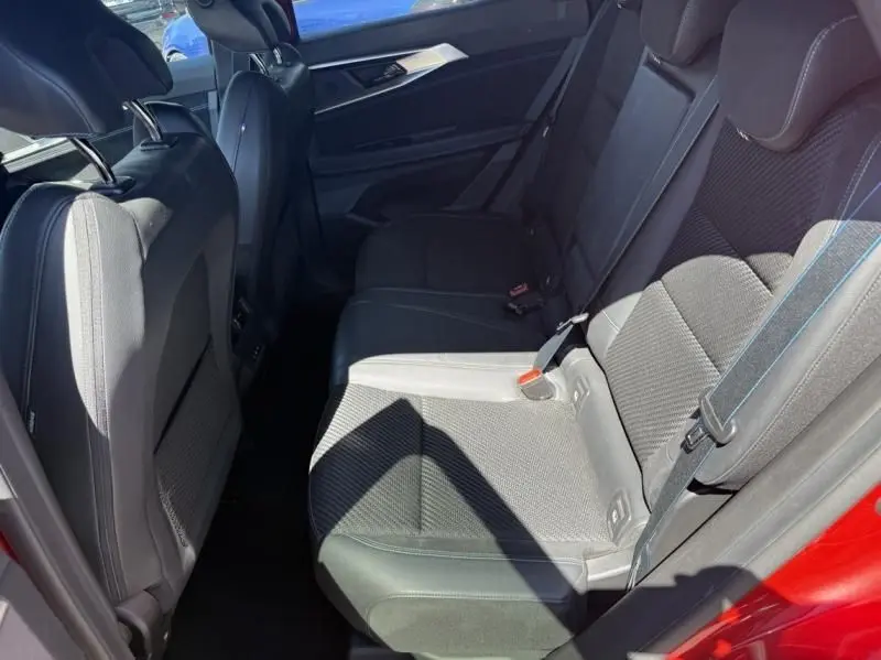 Vue intérieure côté arrière droit des sièges noirs du Renault Austral rouge flamme 2023, version hybride Techno esprit Alpine.