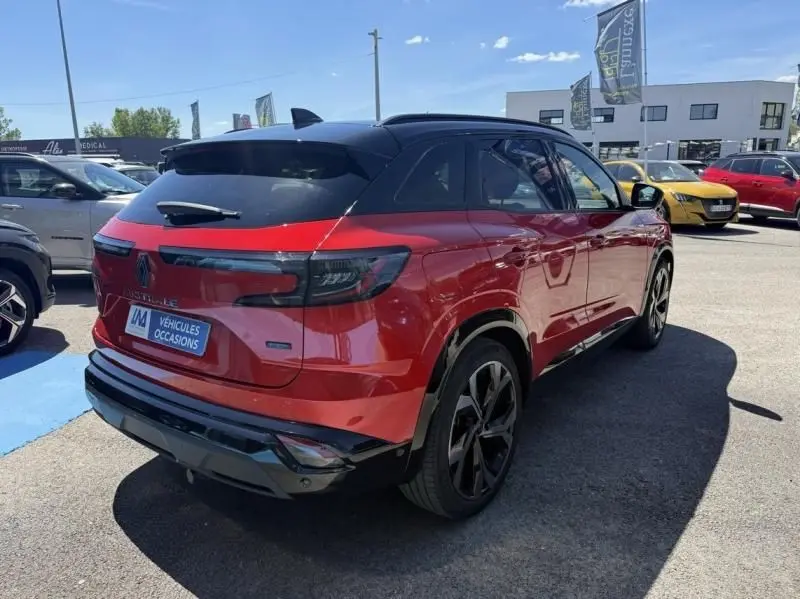 Vue 3/4 arrière droite d'un Renault Austral rouge flamme 2023 avec toit noir et jantes noires distinctives.