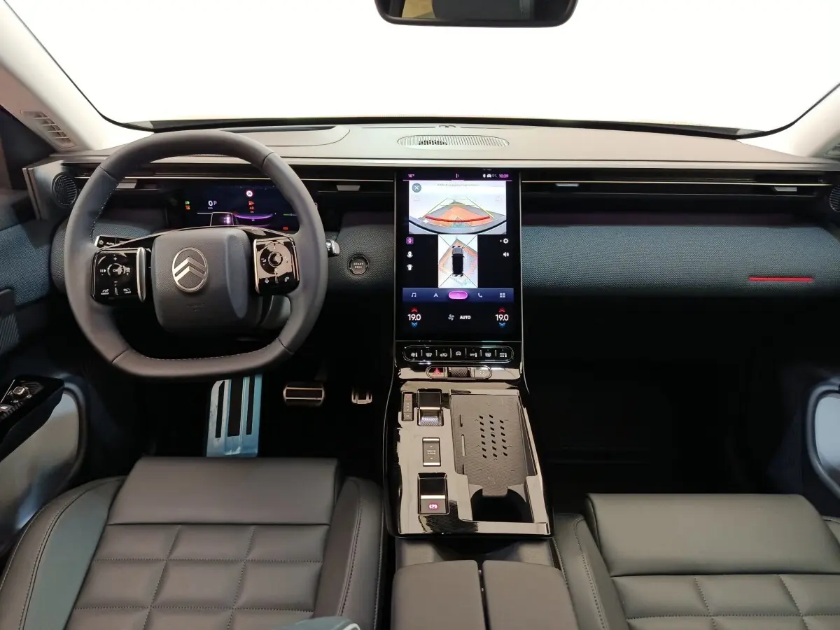 Intérieur de la Citroën C5 Hybride 2025 vu de face, tableau de bord noir avec écran tactile central vertical.