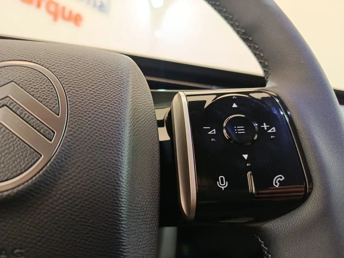 Gros plan sur les commandes multifonctions noires à droite du volant cuir de la Citroën C5 hybride 2025.