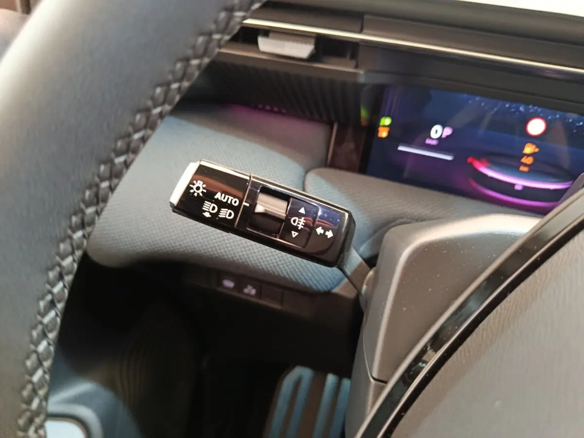 Gros plan sur la commande des phares et clignotants à gauche du volant dans l’habitacle de la Citroën C5 hybride 2025.