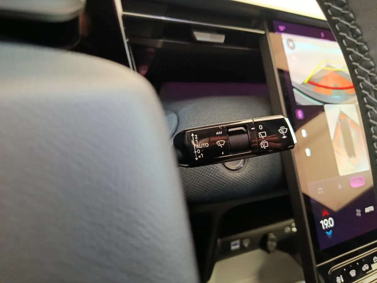Gros plan sur la commande d’essuie-glace à gauche du volant dans l’habitacle gris foncé d’une Citroën C5 Hybride 2025.