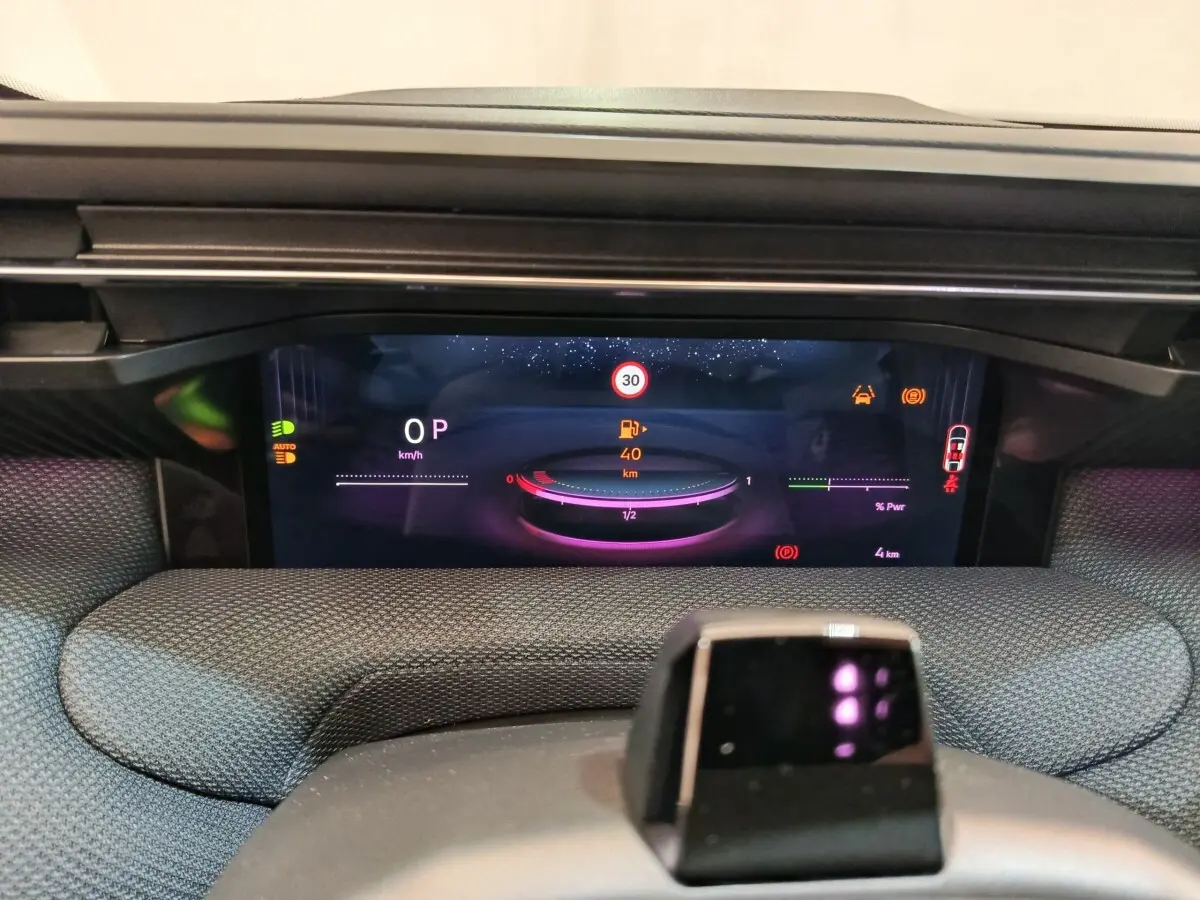 Vue rapprochée du combiné d'instruments numérique de la Citroën C5 Hybride 2025 avec affichage multifonctions coloré.