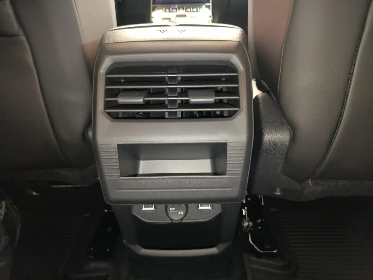 Vue rapprochée de la console arrière noire avec bouches d’aération et prises USB du Citroën C5 Hybride gris foncé.