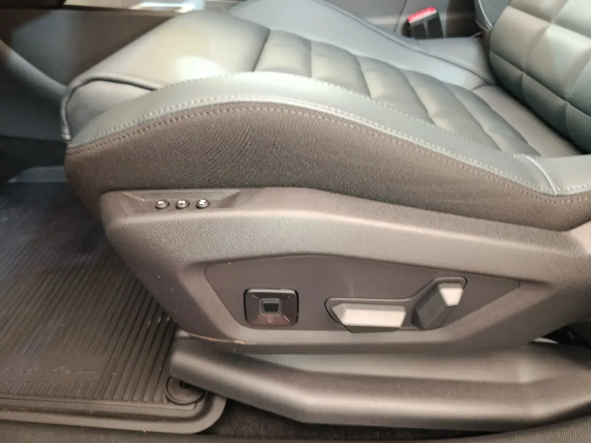 Gros plan sur le côté gauche du siège avant en cuir gris foncé avec commandes électriques sur une Citroën C5 hybride 2025.