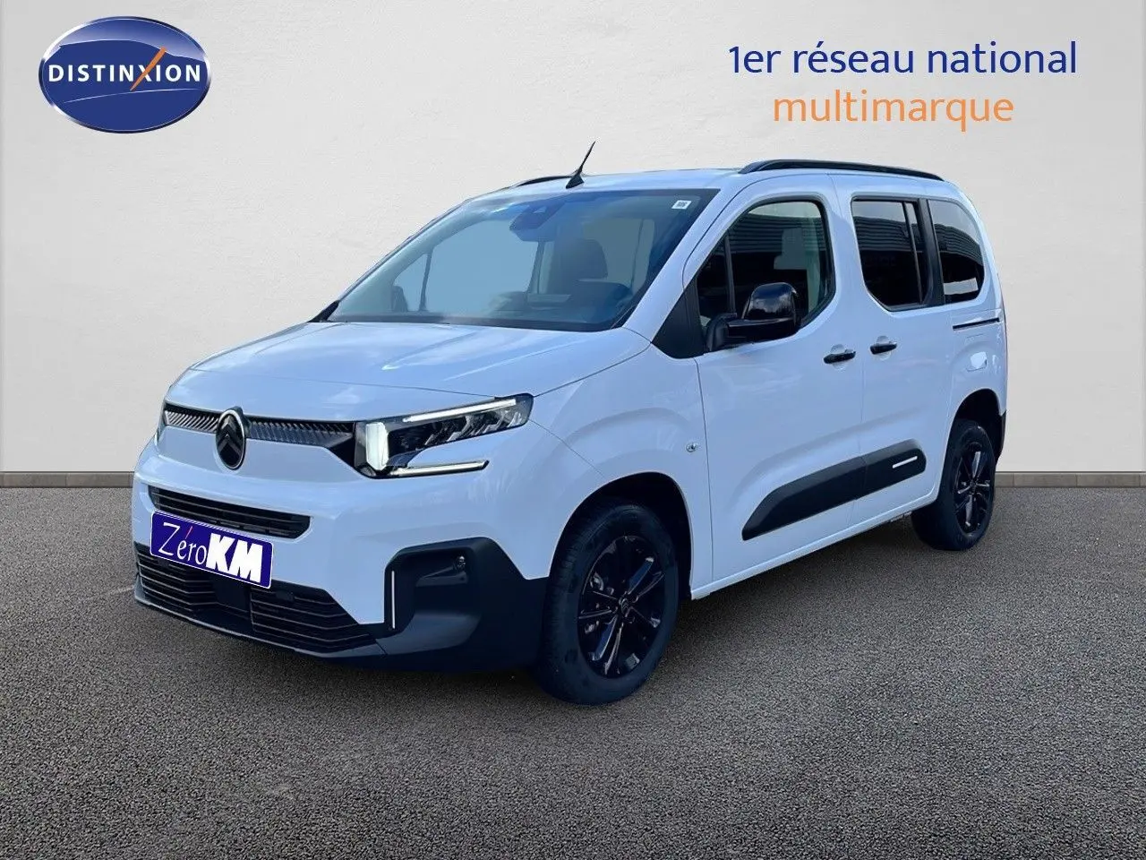 Vue 3/4 avant droite du Citroën Berlingo Multispace blanc glacier avec jantes noires et protections latérales noires.