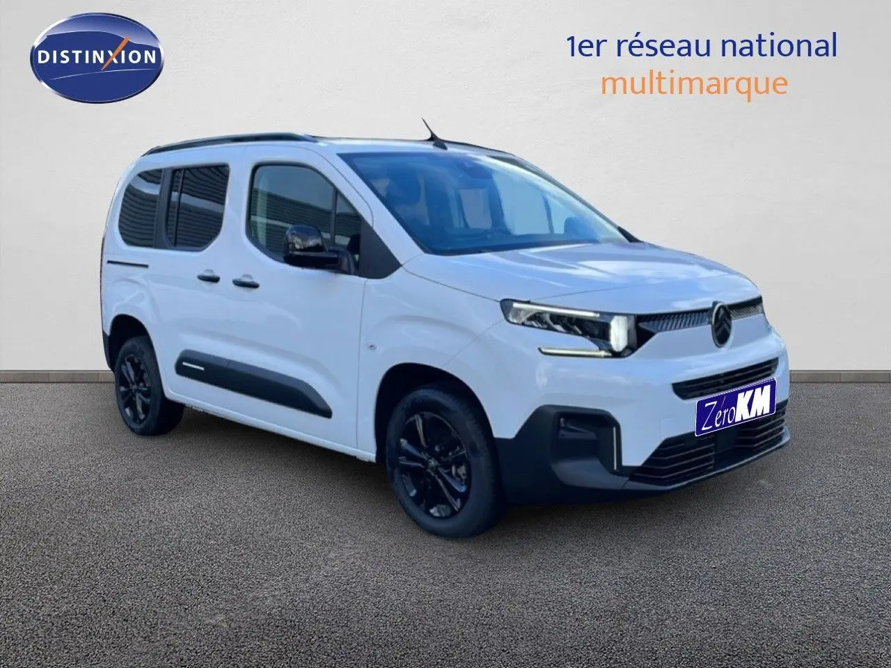 Vue 3/4 avant droit du Citroën Berlingo Multispace blanc glacier avec jantes noires et détails noirs contrastants.