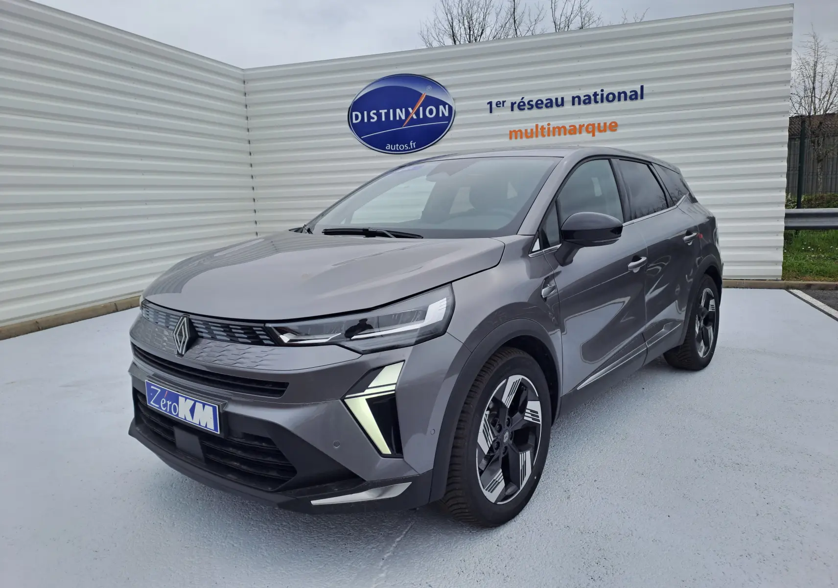 Renault Symbioz gris Cassiope en 3/4 avant droit, avec calandre moderne et jantes alliage bicolores.