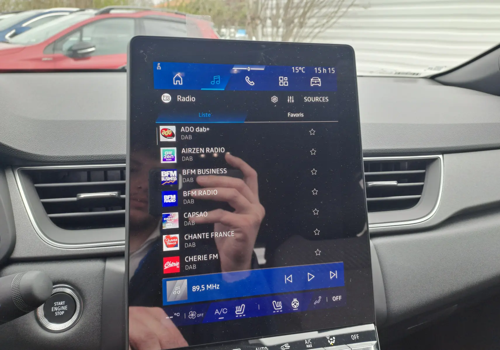 Écran tactile central du tableau de bord du Renault Symbioz gris Cassiope, avec commandes radio et climatisation visibles.