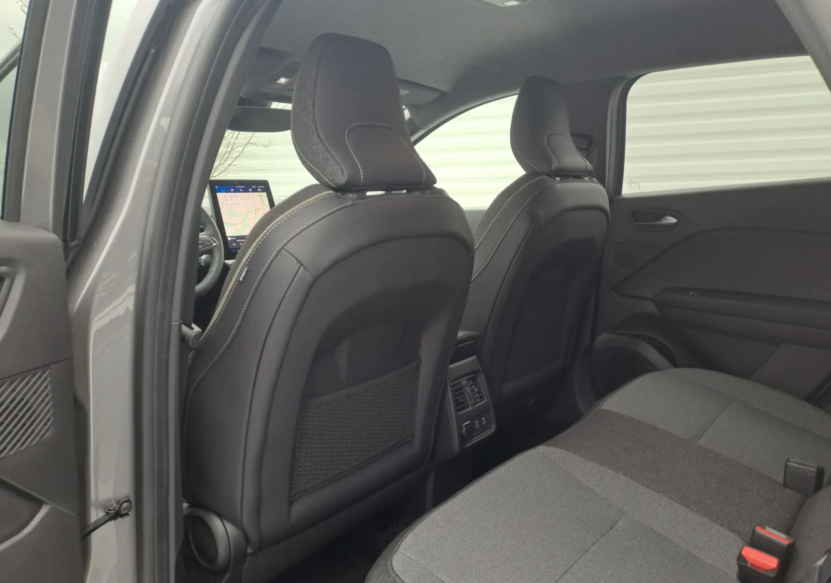 Vue arrière intérieure du Renault SYMBIOZ gris Cassiope, montrant les sièges avant en cuir et la banquette arrière en tissu gris.