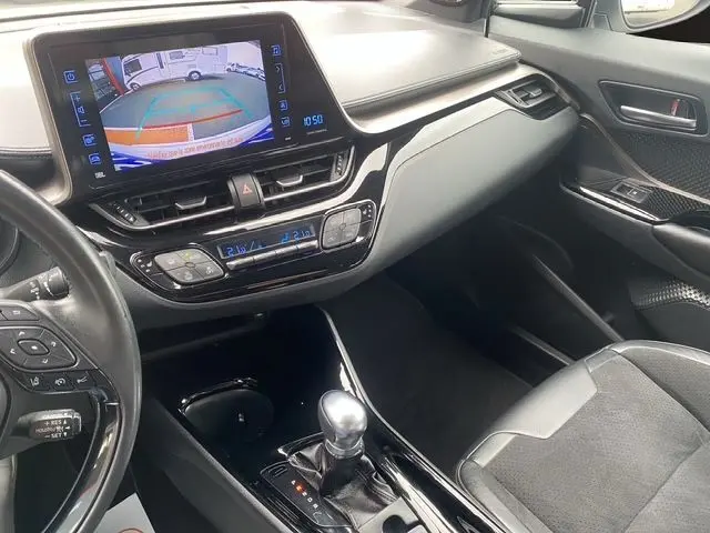 Vue intérieure du Toyota C-HR Hybride 2018 montrant la console centrale noire avec écran tactile et levier de vitesse automatique.