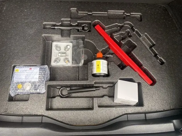 Coffret d’outils et accessoires d’origine Toyota C-HR Hybride 2018, rangés dans le compartiment de coffre.