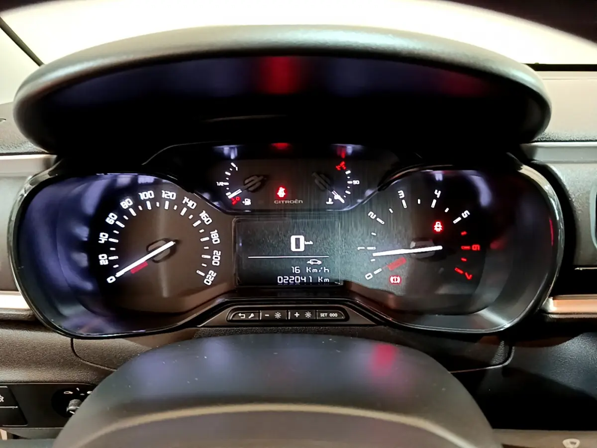 Tableau de bord de Citroën C3 blanc 2018, affichage numérique au centre et compteurs analogiques éclairés.