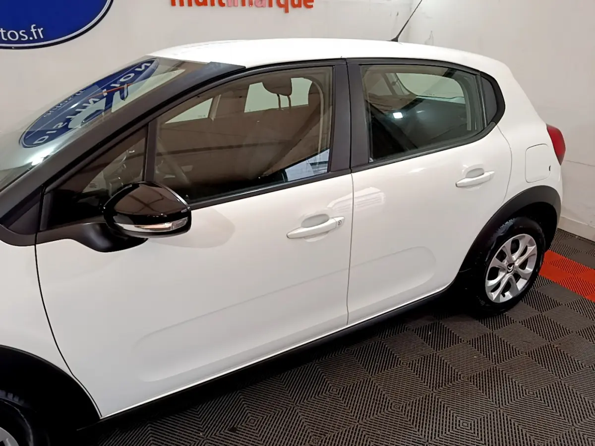 Profil côté gauche d'une Citroën C3 blanche 2018 avec rétroviseurs noirs et poignées de porte assorties.