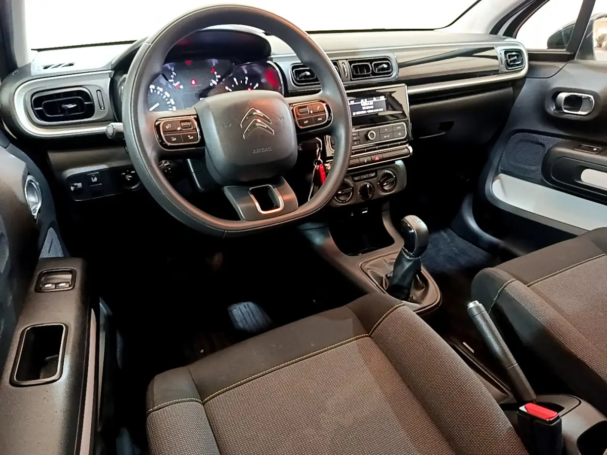 Intérieur de la Citroën C3 PureTech 68 BVM Feel 2018, vue avant côté conducteur avec tableau de bord noir et volant multifonctions.