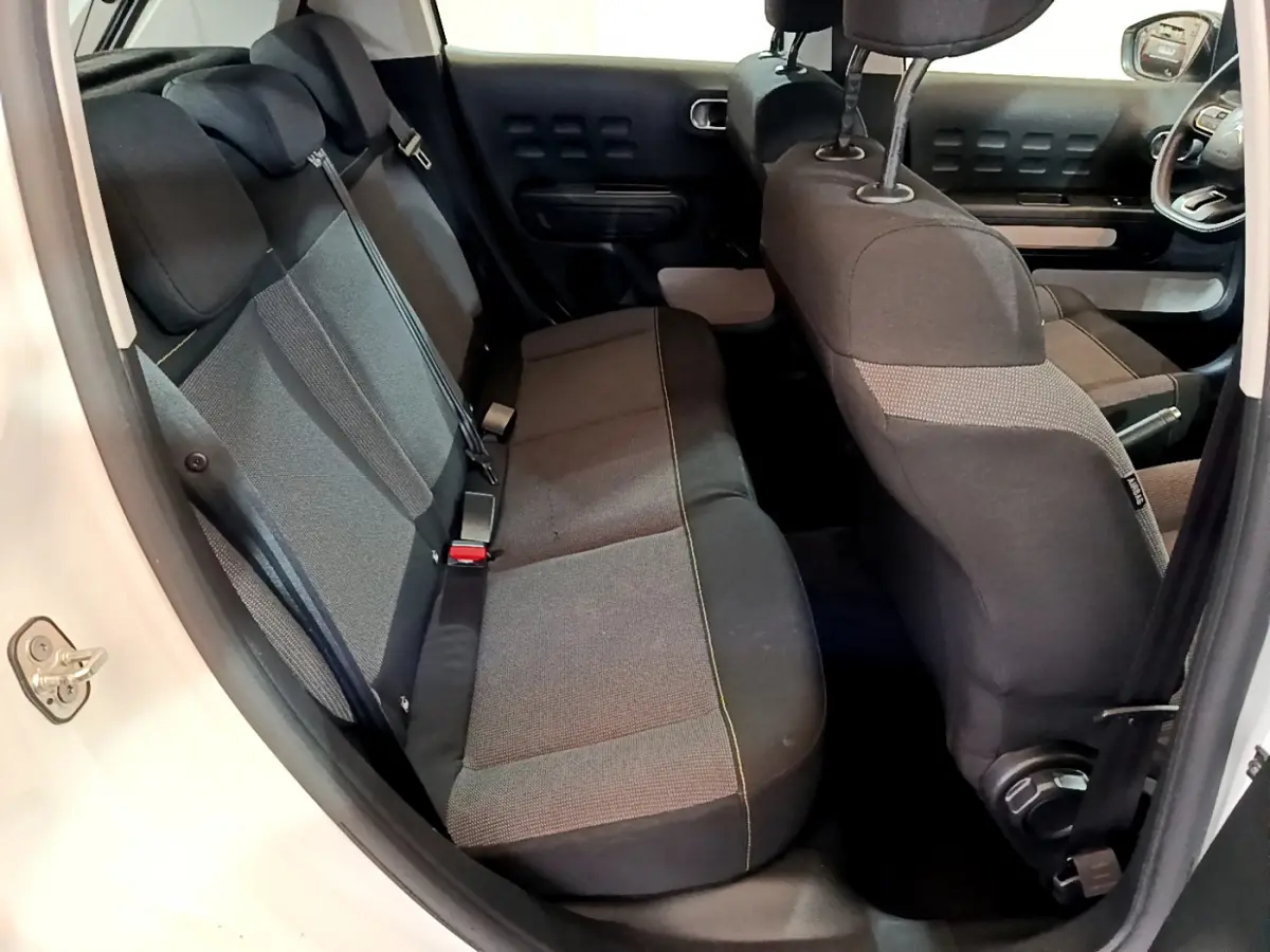 Vue intérieure côté droit de la banquette arrière et sièges avant noirs d'une Citroën C3 blanche 2018.