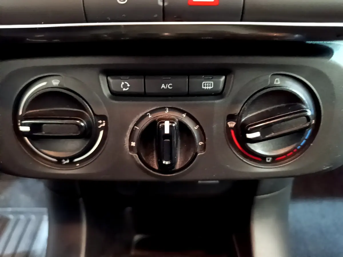 Commandes de climatisation manuelle de la Citroën C3 PureTech 68 BVM Feel 2018, vue rapprochée du tableau de bord noir.