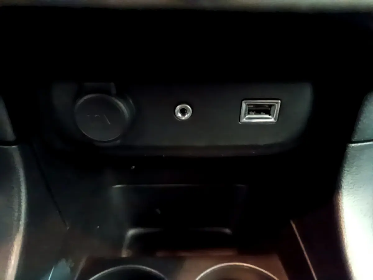 Prise USB, prise jack et allume-cigare dans la console centrale d'une Citroën C3 blanche PureTech 68 BVM Feel 2018.