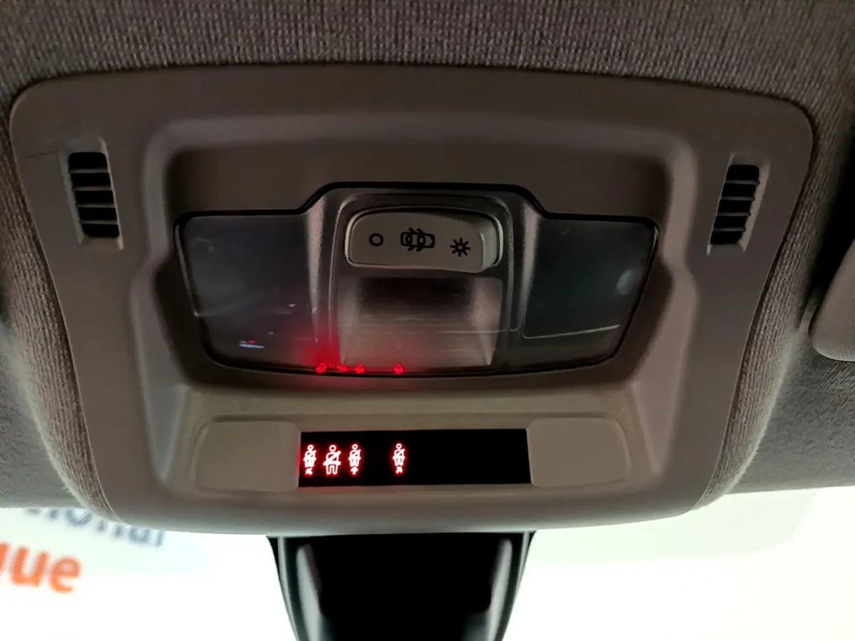 Vue en gros plan du plafonnier intérieur de la Citroën C3 blanc 2018 avec témoins de ceinture allumés.