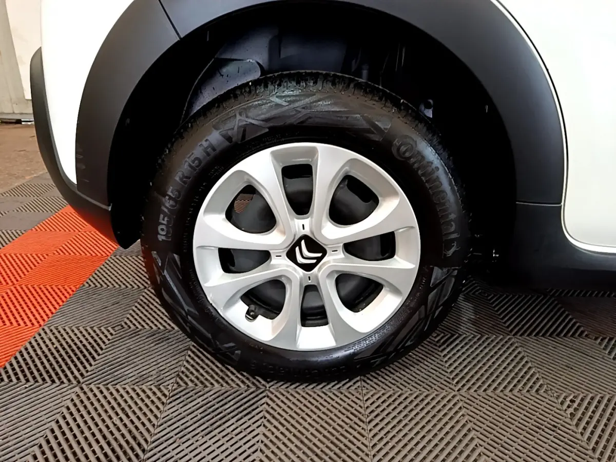 Gros plan sur la roue avant droite d'une Citroën C3 blanche, avec jante alliage et logo Citroën central.