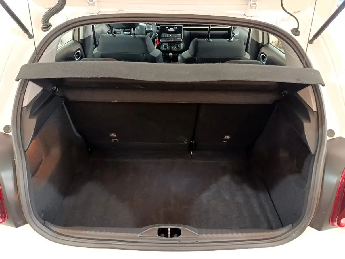 Vue arrière du coffre ouvert d'une Citroën C3 blanche de 2018, montrant l'intérieur spacieux et la banquette arrière.