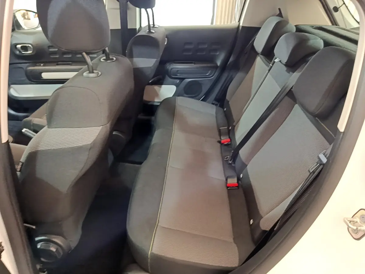 Vue intérieure côté droit sur la banquette arrière grise et les sièges avant d'une Citroën C3 blanche 2018.