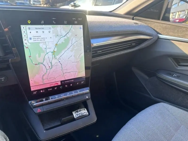 Vue intérieure côté passager de la Renault Mégane E-Tech Electric 2023 avec écran tactile central et détails de la console.