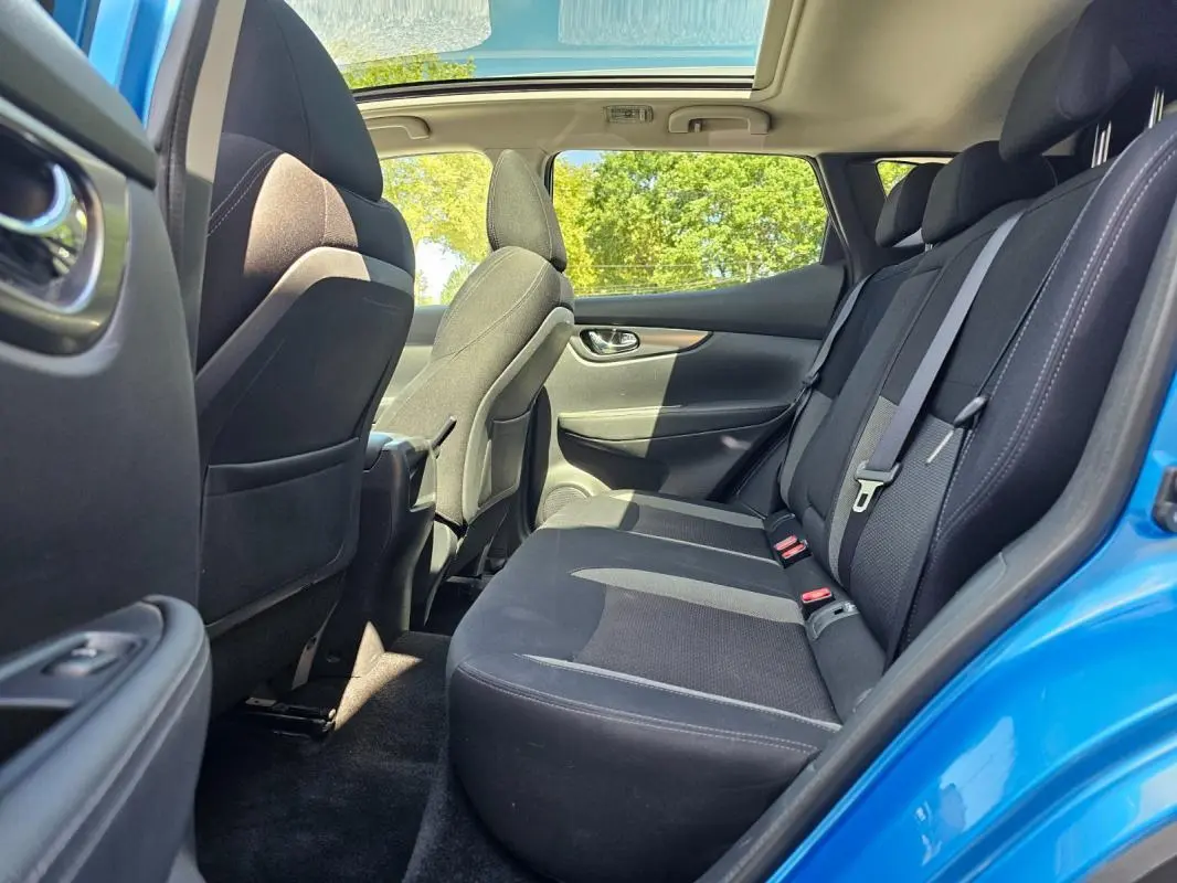 Vue intérieure arrière côté droit du Nissan Qashqai bleu 2019, montrant les sièges noirs et la porte ouverte.