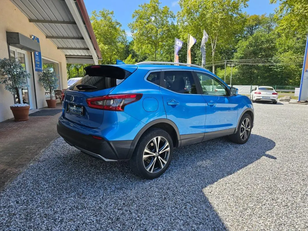 Vue 3/4 arrière droite d'un Nissan Qashqai bleu 2019, version N-Connecta avec jantes alliage et toit noir.