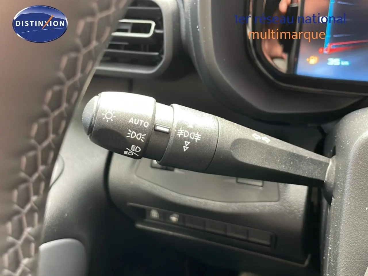 Gros plan sur la commande des feux et clignotants à gauche du volant dans l’habitacle du Citroën Berlingo gris Artense 2026.