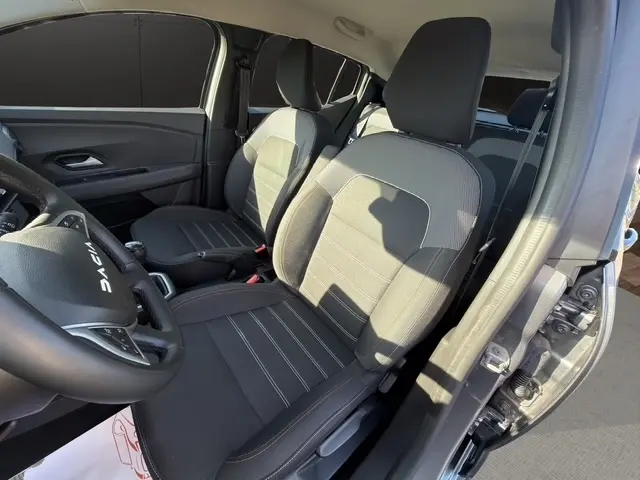 Vue intérieure côté conducteur de la Dacia Sandero Stepway gris foncé, sièges tissu et volant multifonctions cuir synthétique.