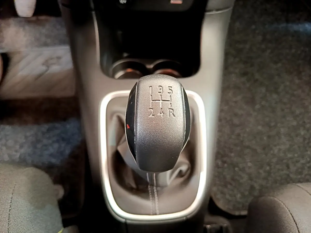 Gros plan sur le levier de vitesse manuel noir de la Citroën C3 gris foncé, entouré de garniture argentée.