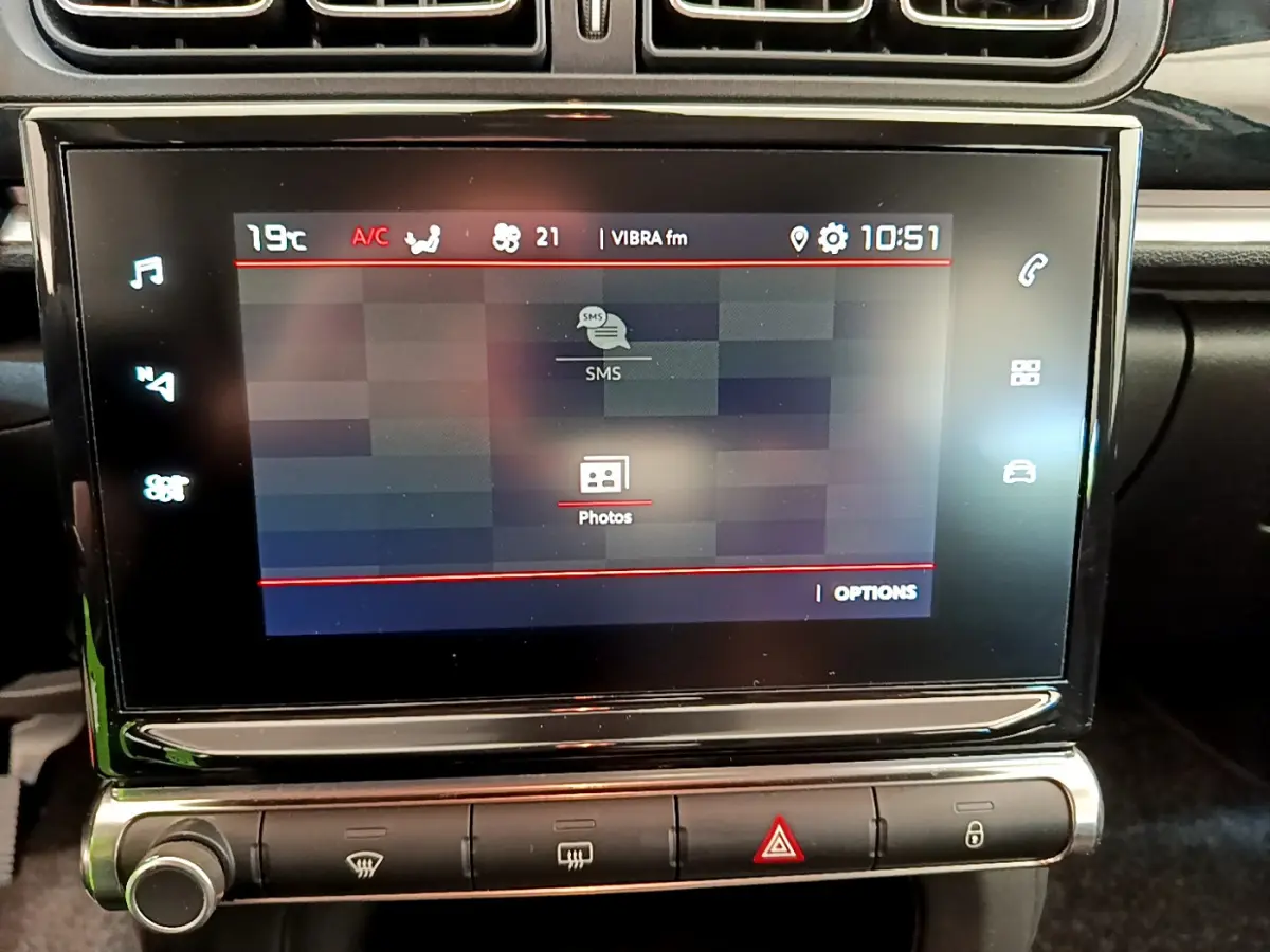 Écran tactile central de la CITROEN C3 2019 affichant les options SMS et photos, avec commandes climatisation en dessous.